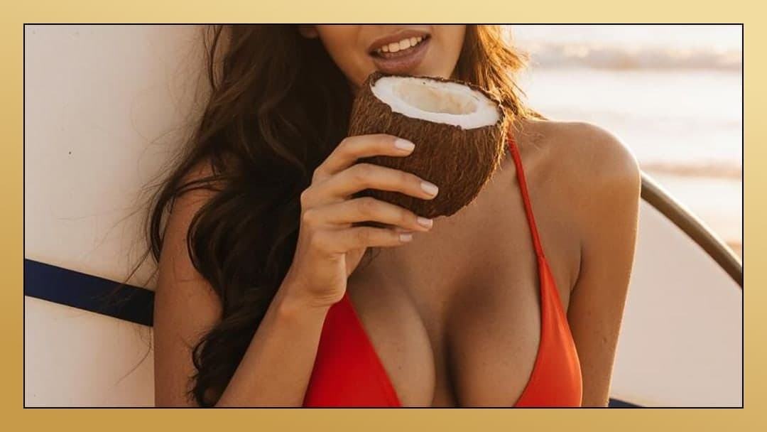 Young adult sipping coconut on boat