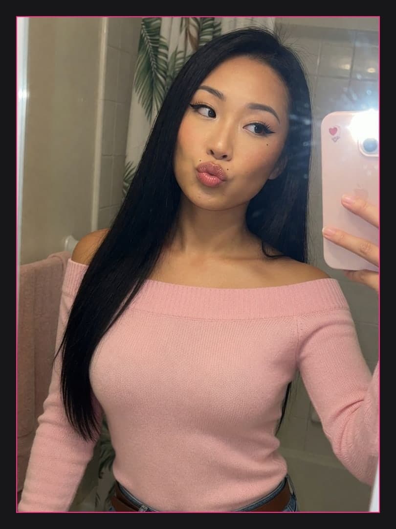 Bathroom mirror selfie in pink sweater