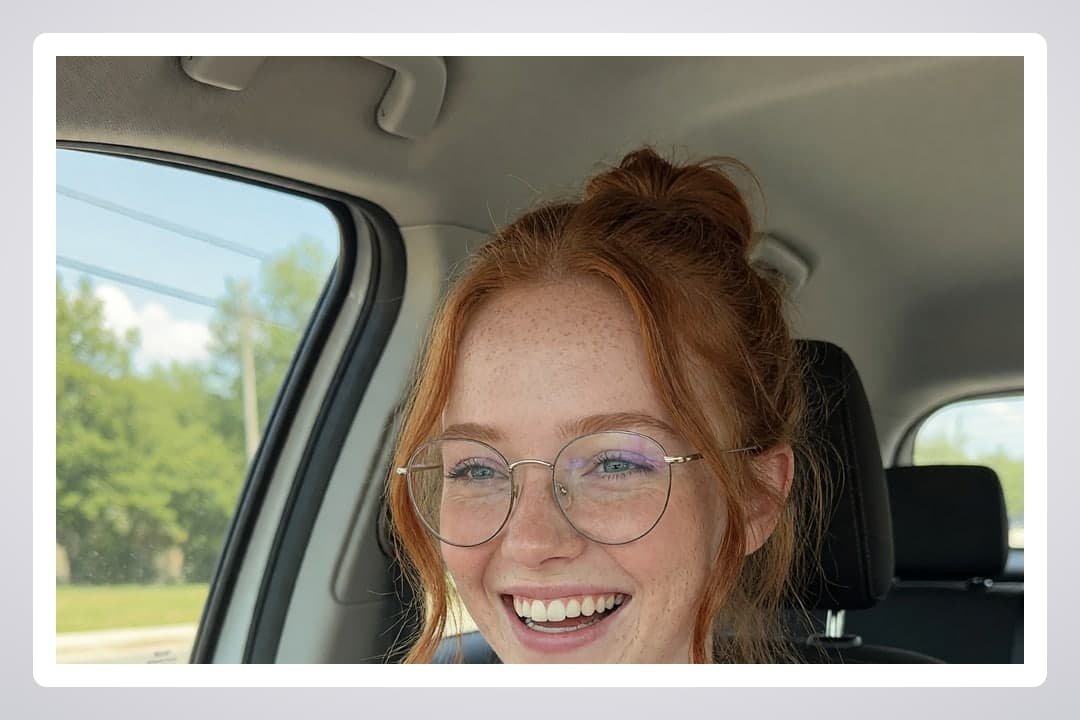 Redhead with glasses in car