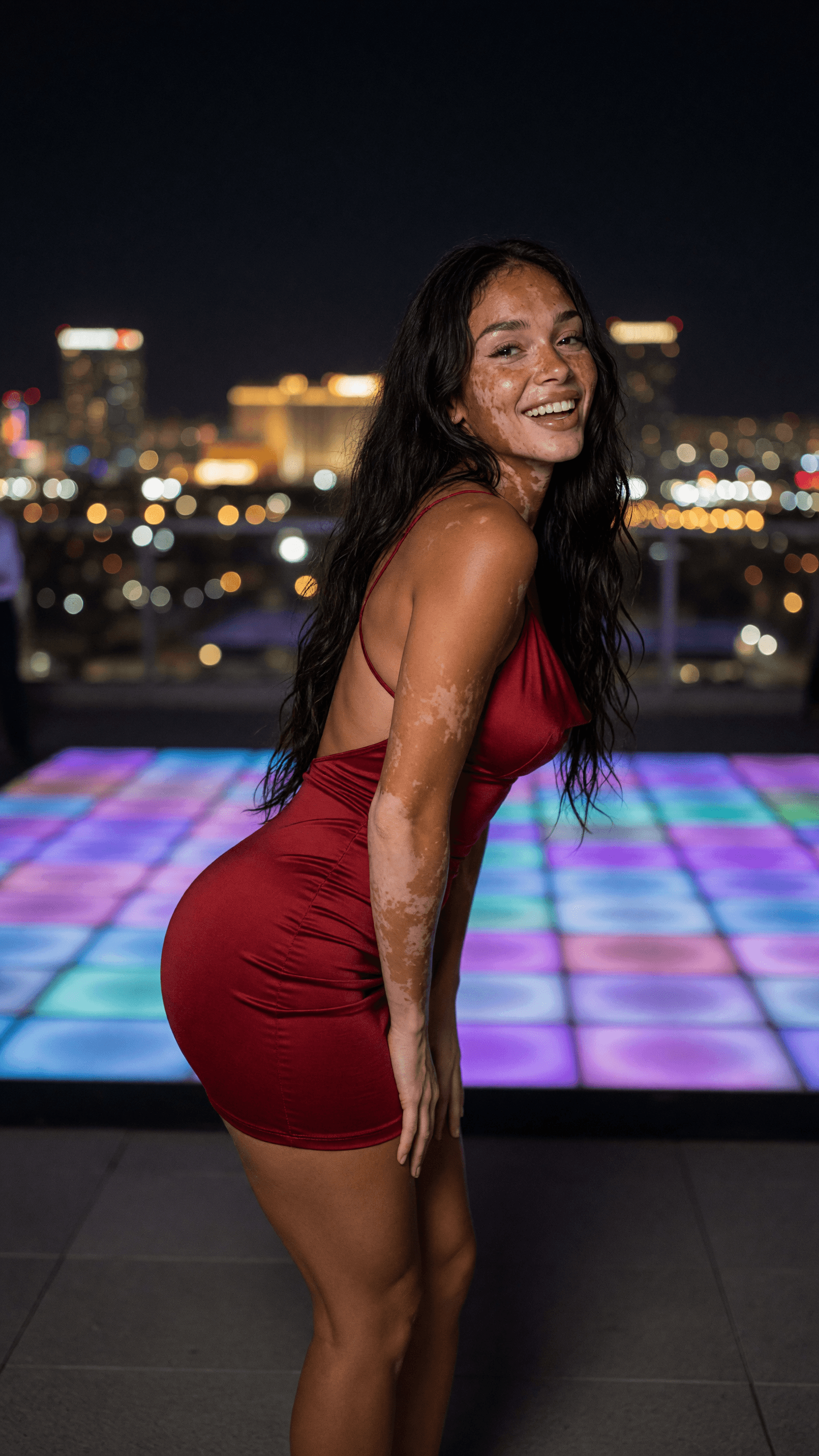 Back view red dress on rooftop city night