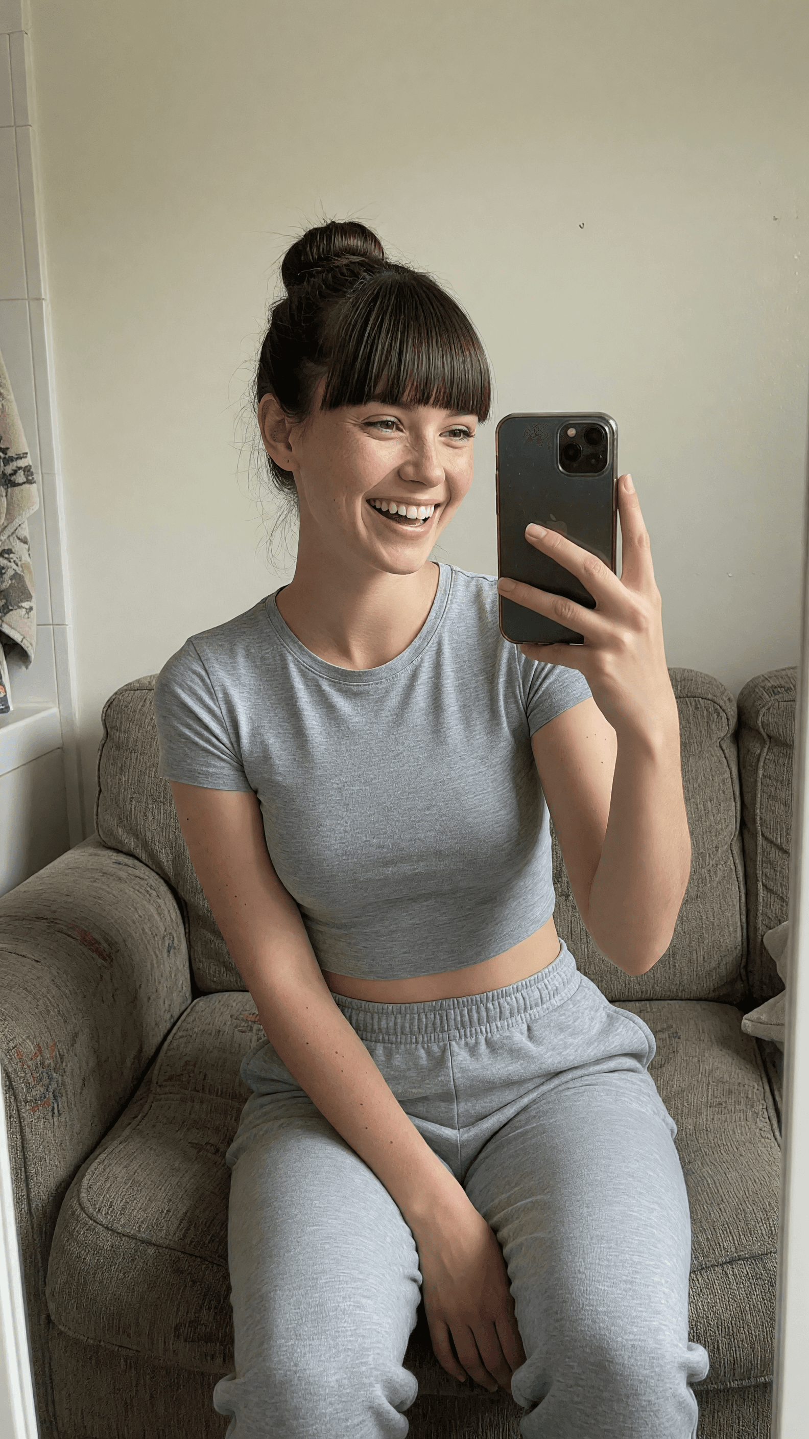 Brunette in crop top taking couch selfie