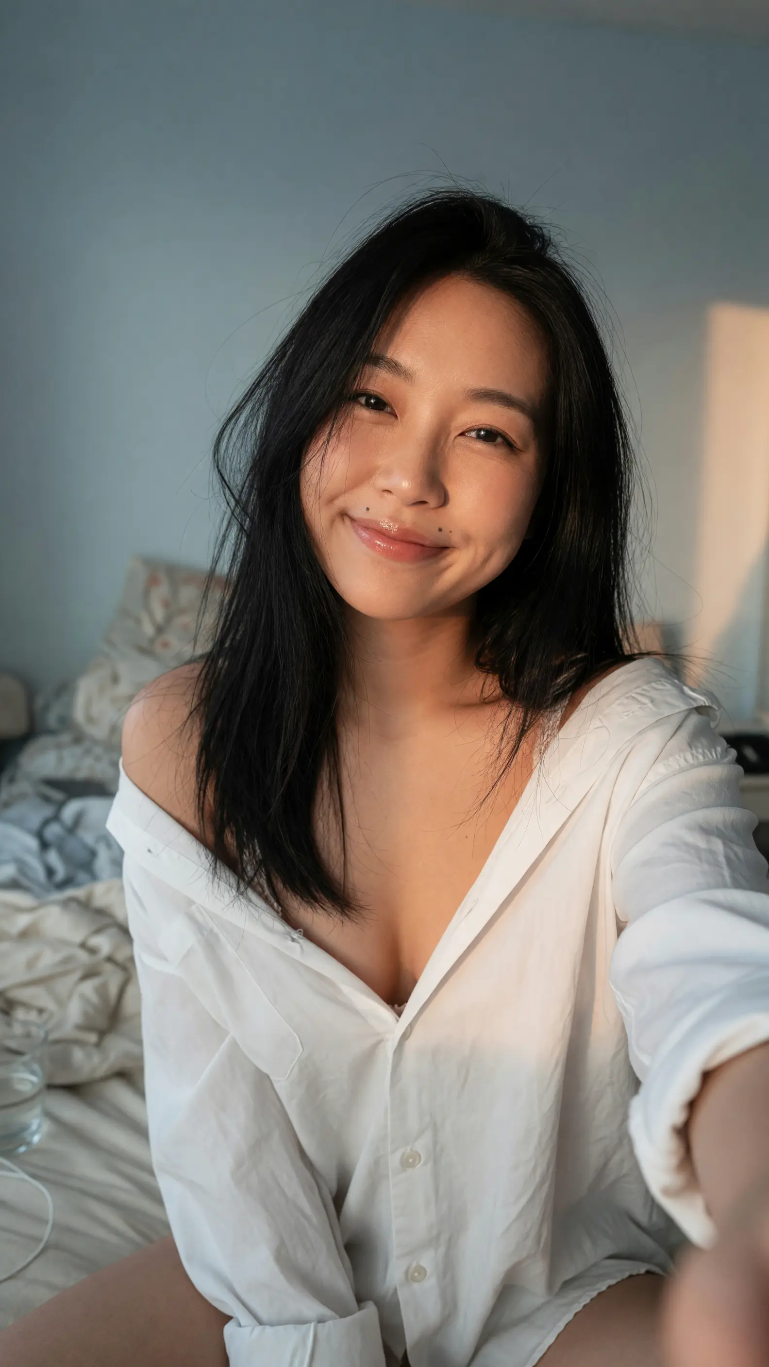 Unbuttoned shirt selfie on bed