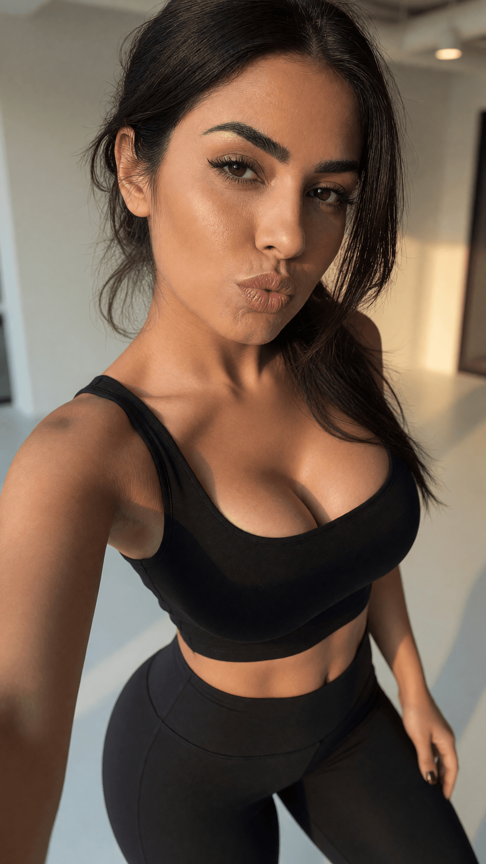 Curvy brunette selfie in sports bra