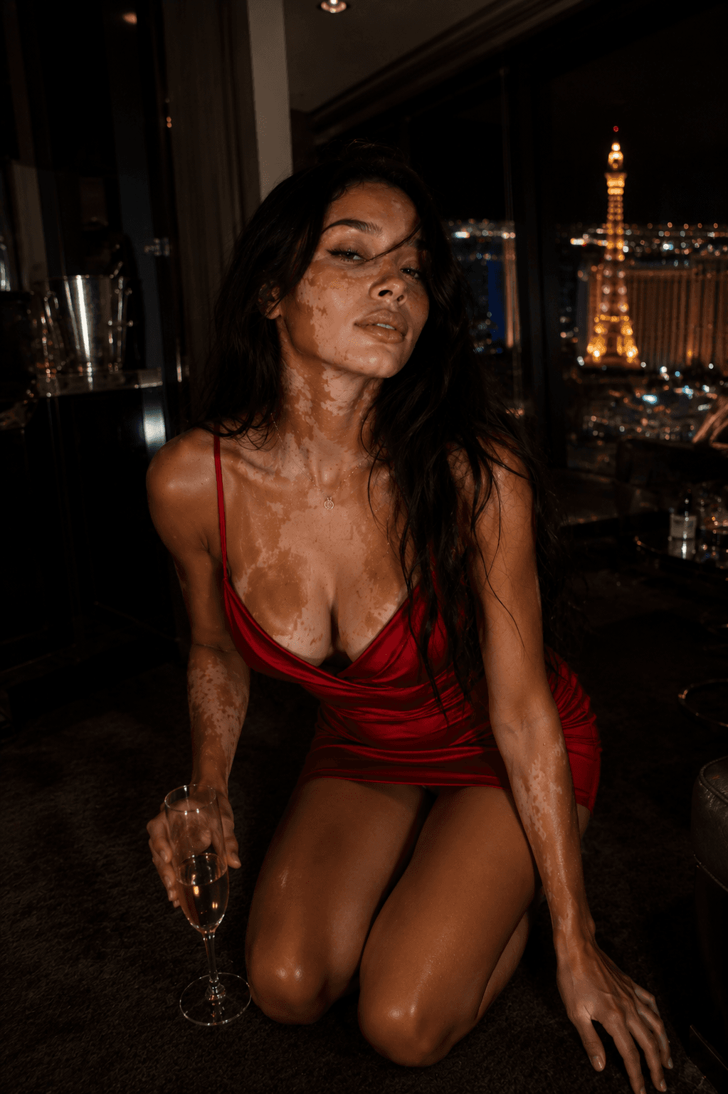 Young adult in red satin dress kneeling city view