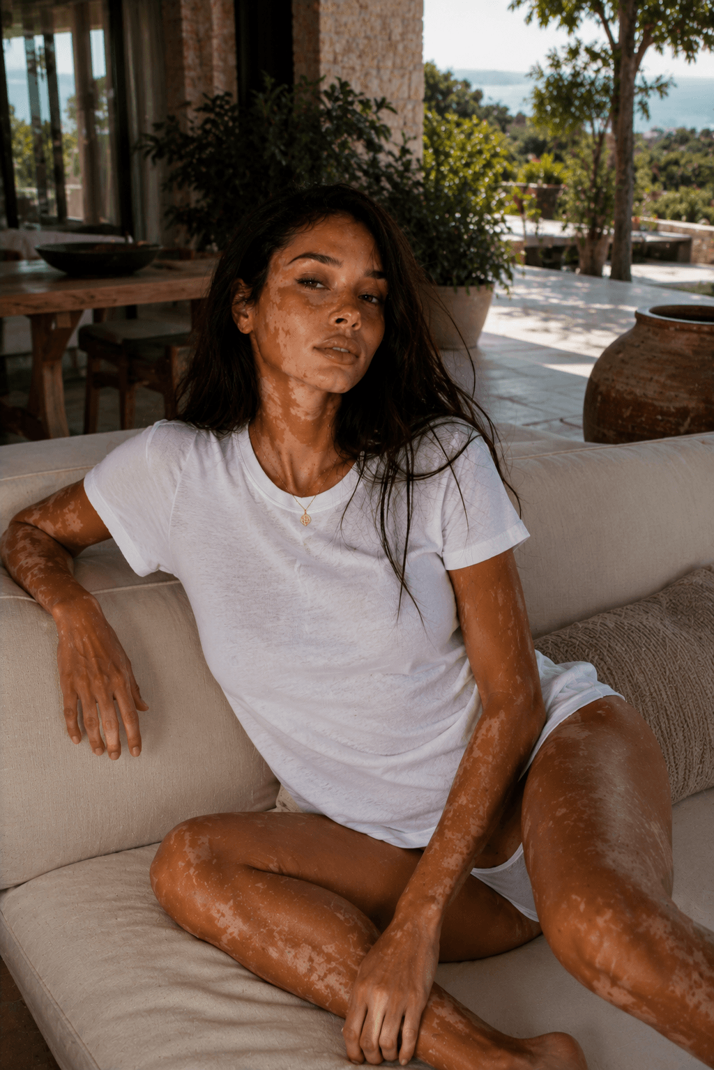 Slim brunette in white tee and panties on sunny patio