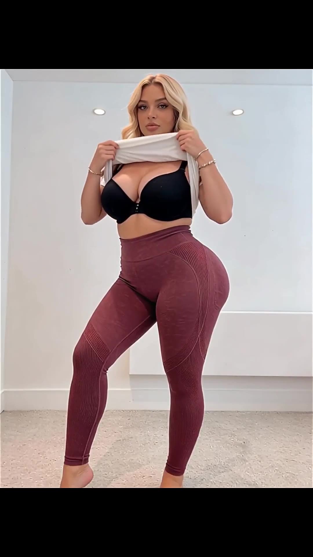 Full body front view curvy brunette lifting crop top