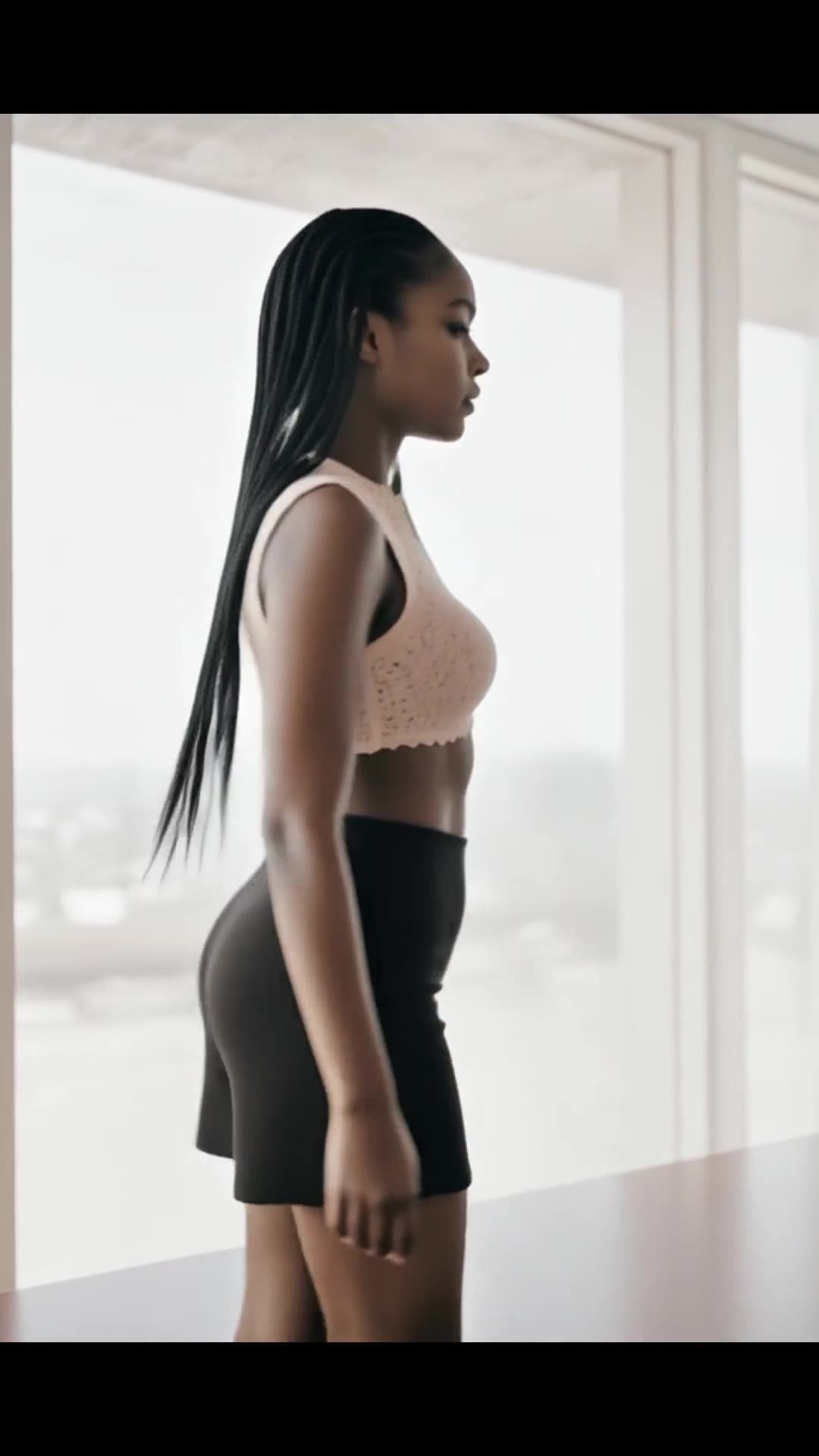 Curvy Asian in peach lace bra and mini skirt standing profile