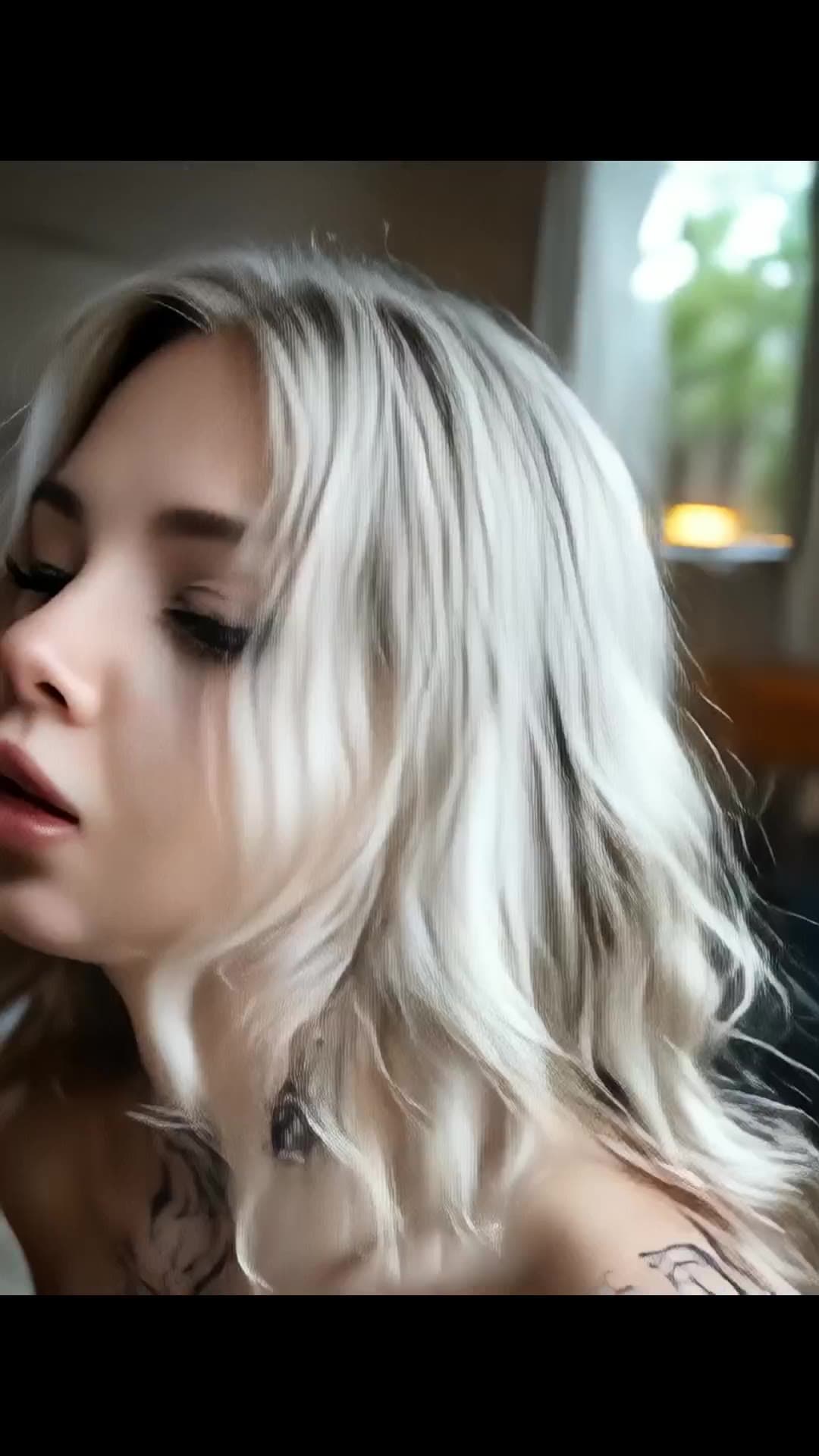 Platinum blonde topless close-up with chest tattoos