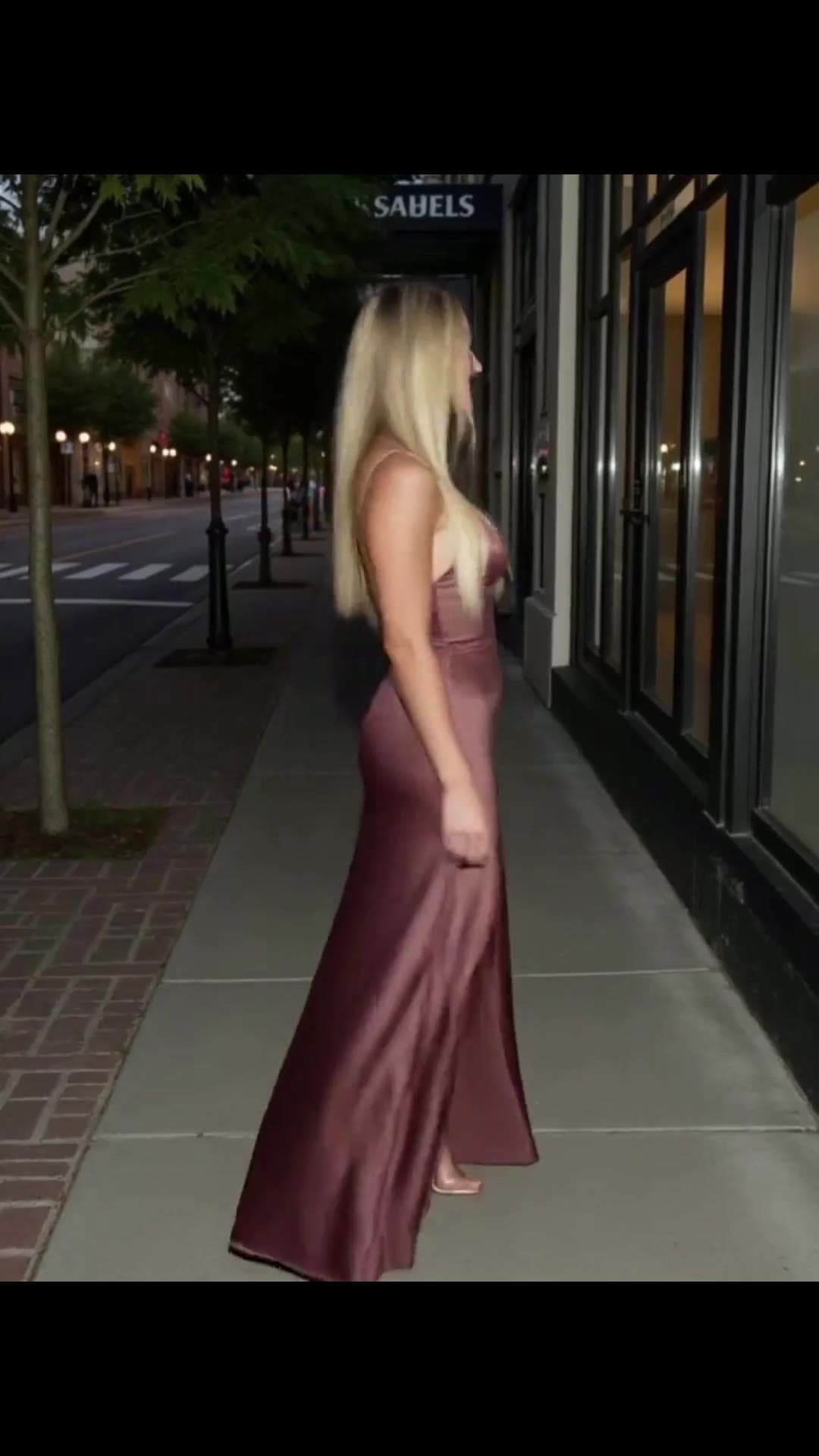 Platinum blonde in mauve satin gown sidewalk at night