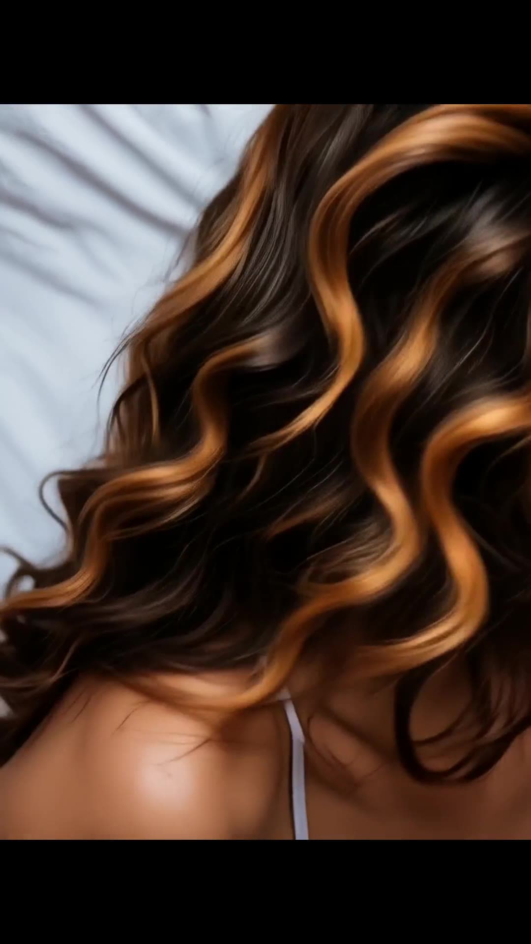 Athletic brunette body on white sheets close-up