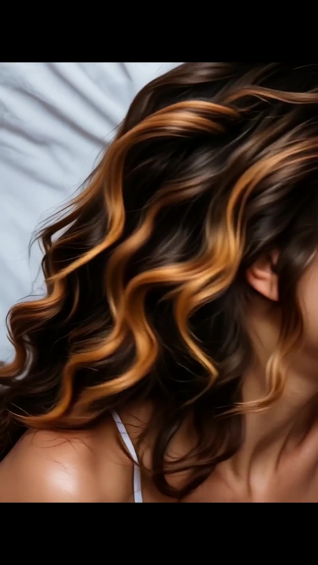 College girl with caramel waves on white sheets