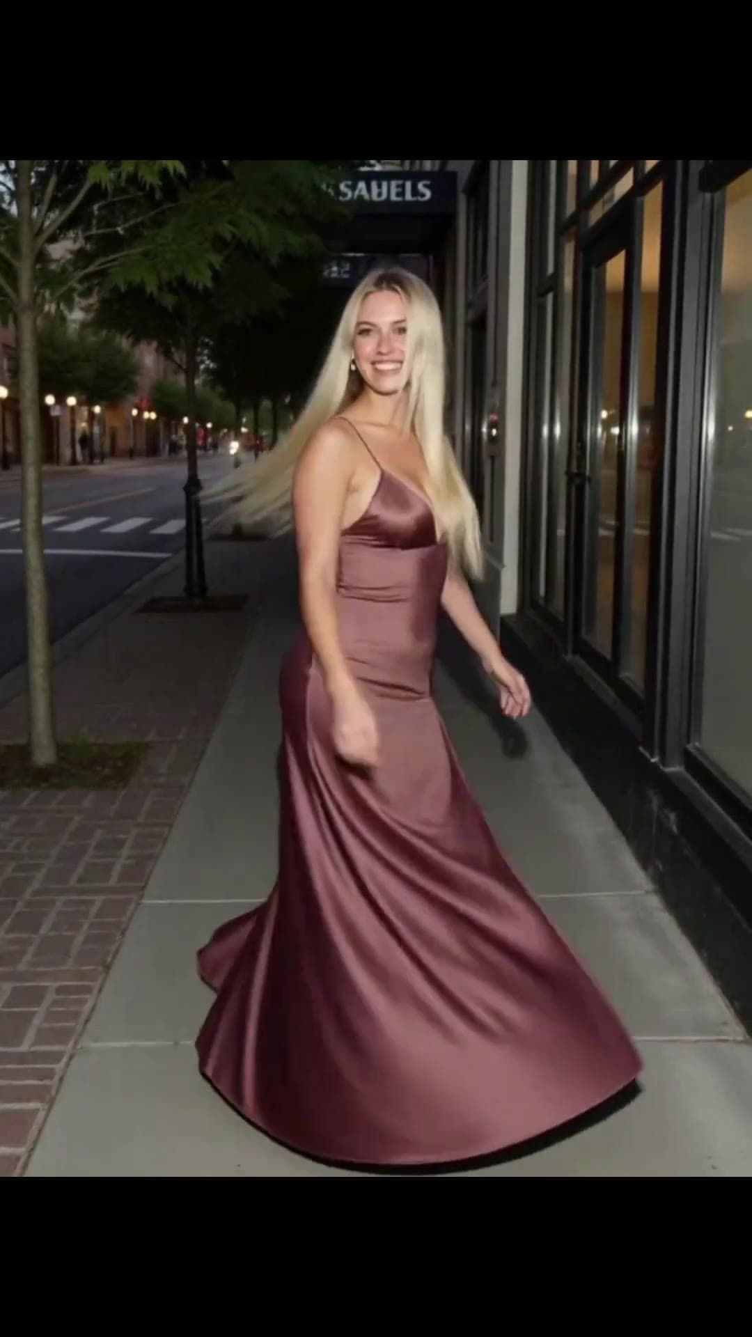 Young adult blonde in satin dress on night street
