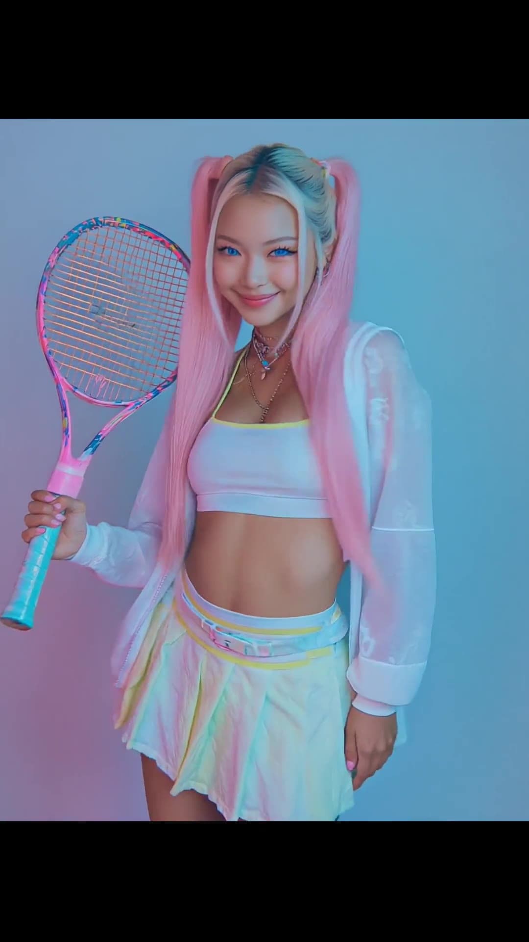 Young adult in rainbow skirt teasing with racket