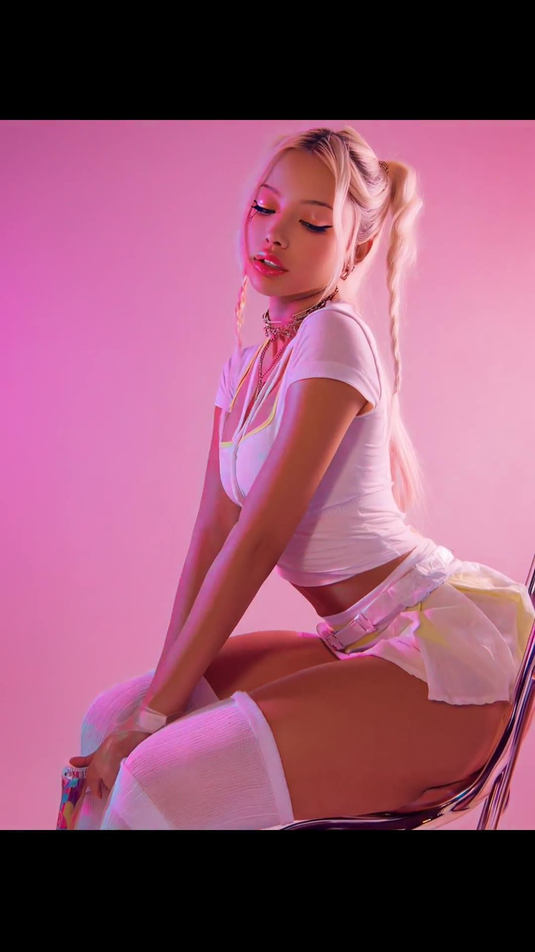Young adult blonde in sheer skirt on pink chair