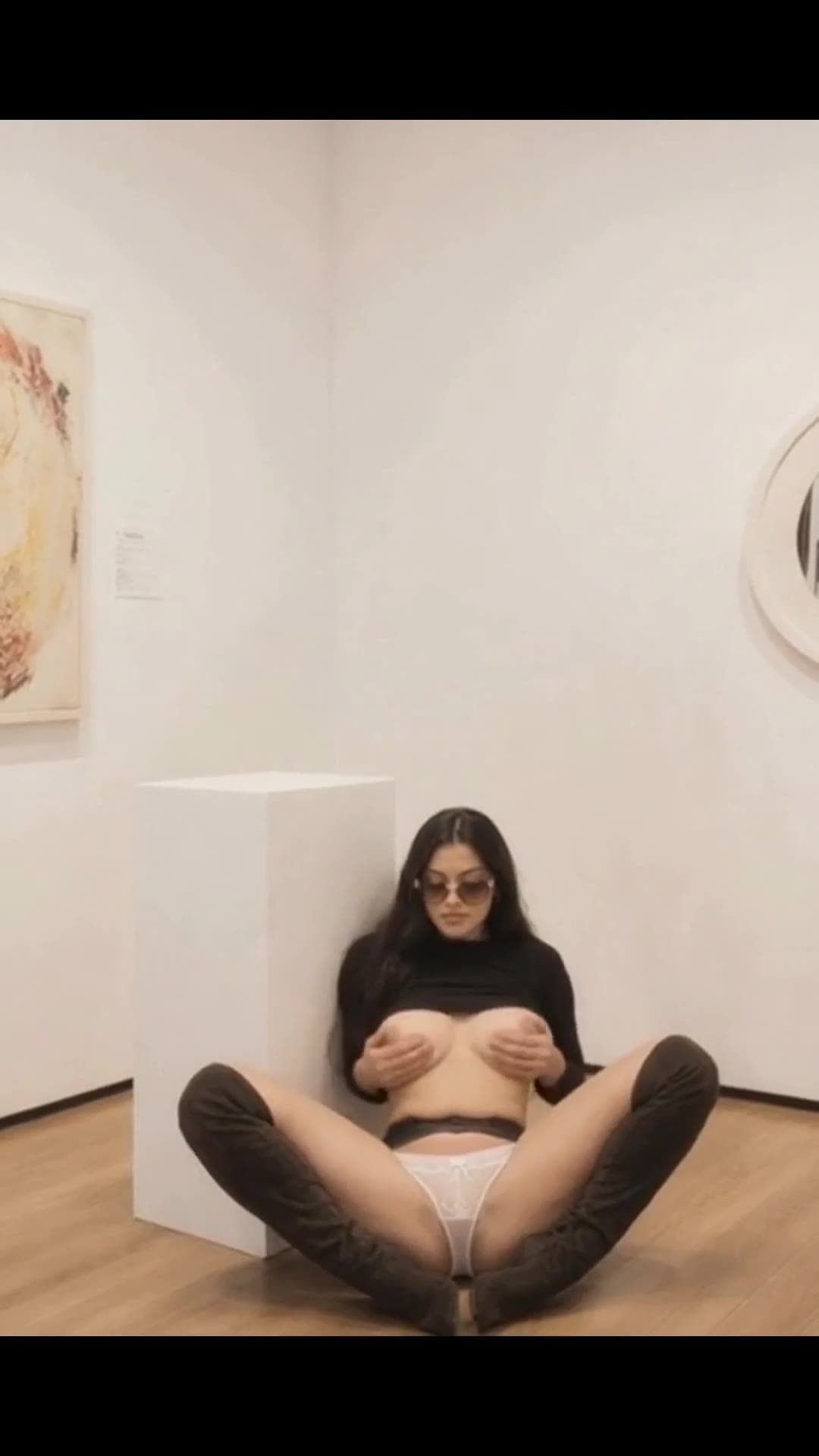 Brunette squeezes tits in gallery