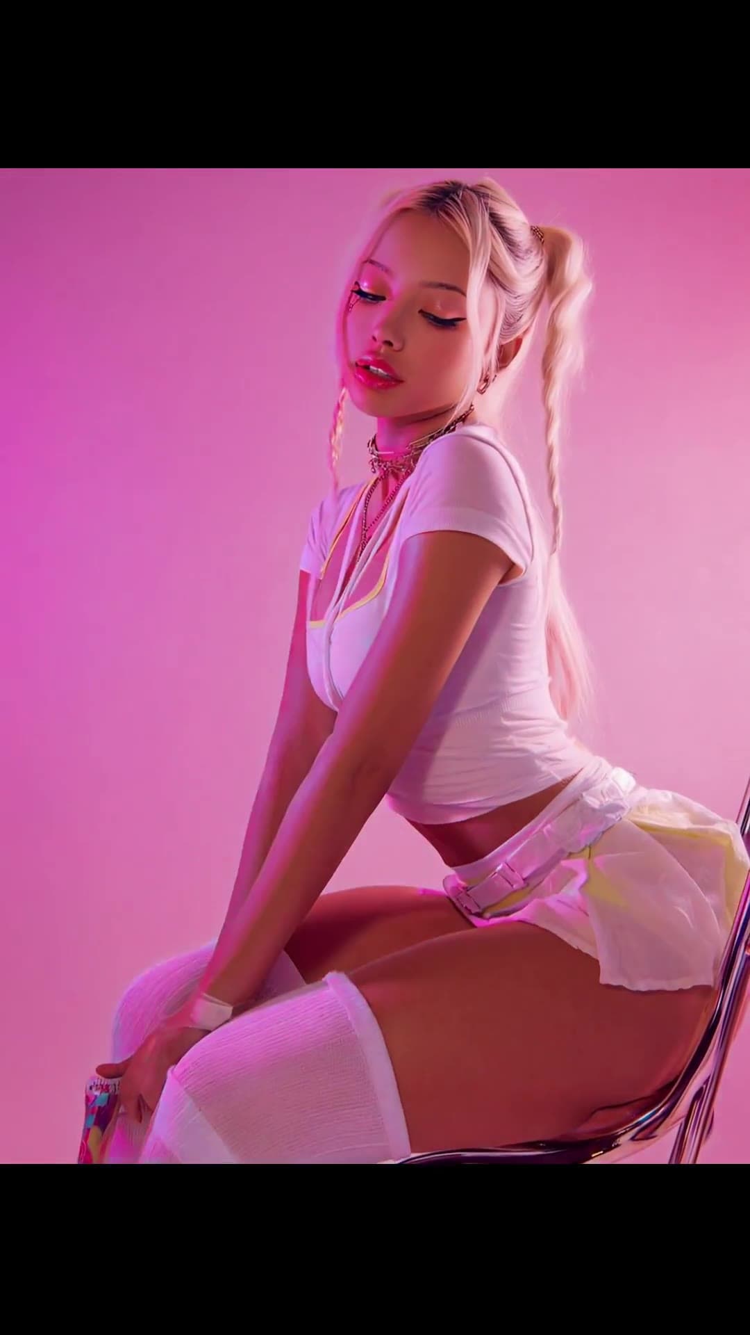 Curvy blonde pigtails on pink neon chair