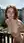 Redhead leans over balcony railing