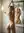 Nude blonde stretches in bathroom mirror