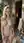 Nude blonde holds herself open in courtyard