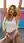 Young curvy blonde stretching in white crop top on rooftop