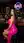 Curvy brunette in pink dress at neon bar