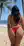 Vera by the ocean in a red bikini