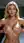 Curvy blonde lifts breasts in light