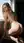 Nude blonde on stool looking back