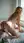 Nude on all fours in sunlit bedroom