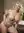 Blonde nude on bed edge smiling