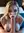 Freya kneeling topless in the bedroom
