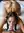 Imara in a dim warm bedroom, braids tousled, arched back and a glance over her shoulder