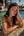 Young adult brunette by sunny pool in tiny white bikini