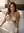 Imani Reyes reclined on bed with white sheet