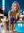 Platinum blonde leans over poolside