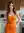 Wavy brunette in orange dress